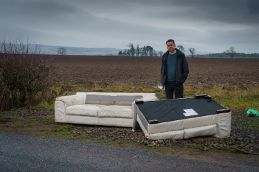 Murdo Fraser MSP beside some fly-tipping